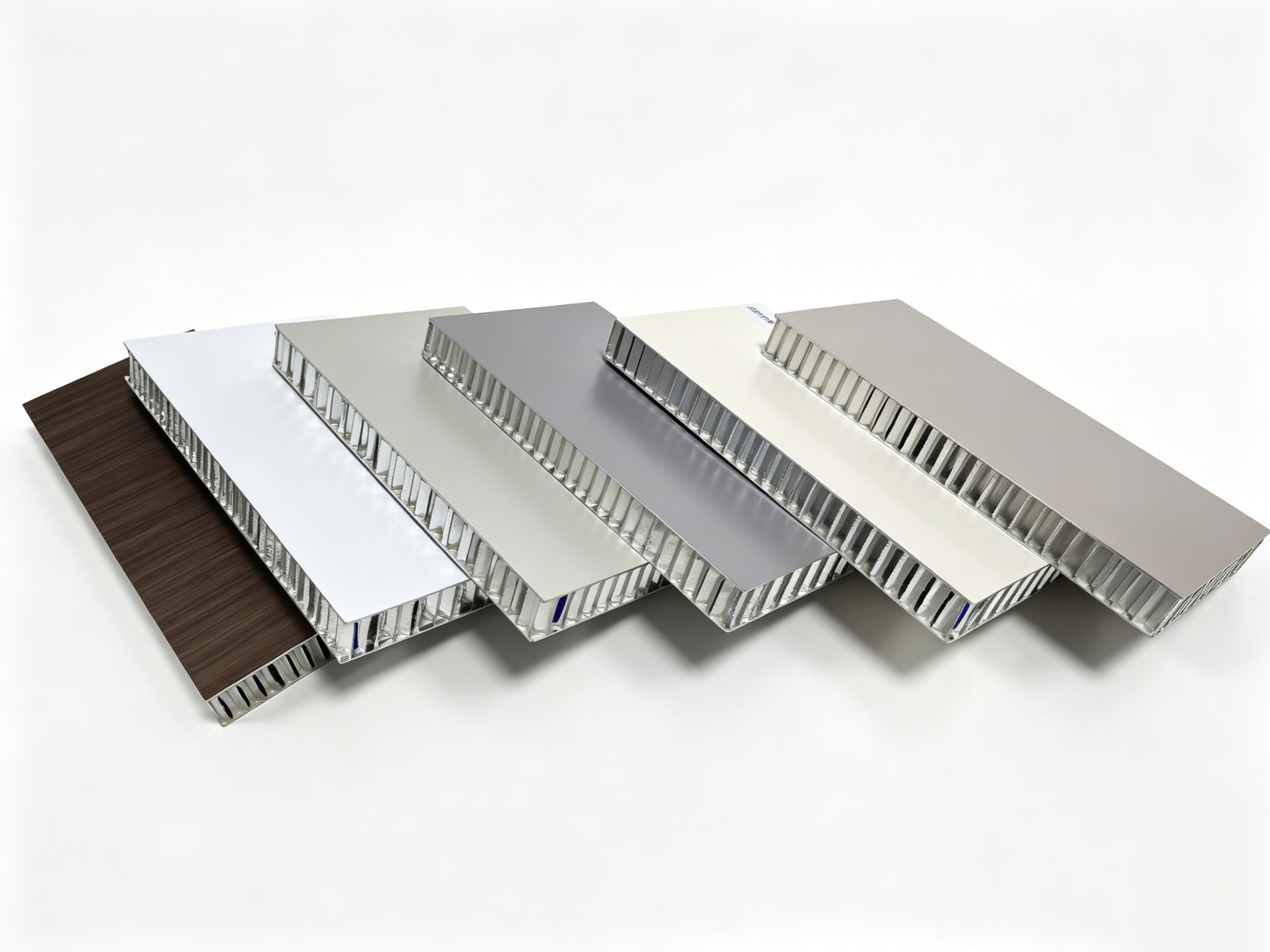 Overlapping honeycomb panel samples with exposed metal cores, pale faces and one woodgrain face
